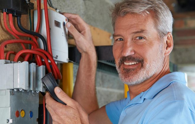 Portrait Of Man Taking Reading From Electricity Meter